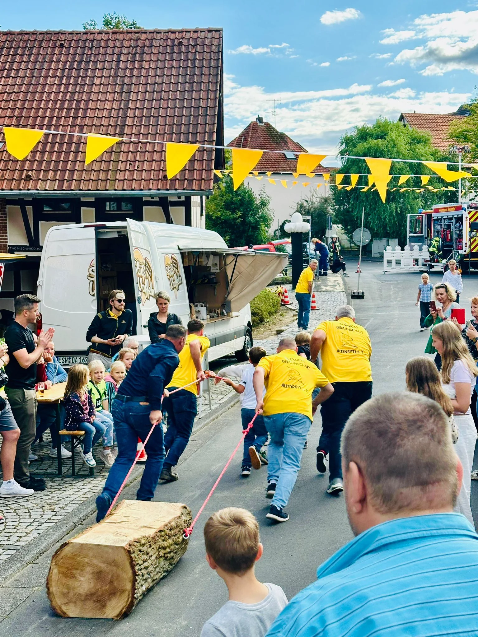 Teilnehmende beim Baumstammziehen vor Publikum
