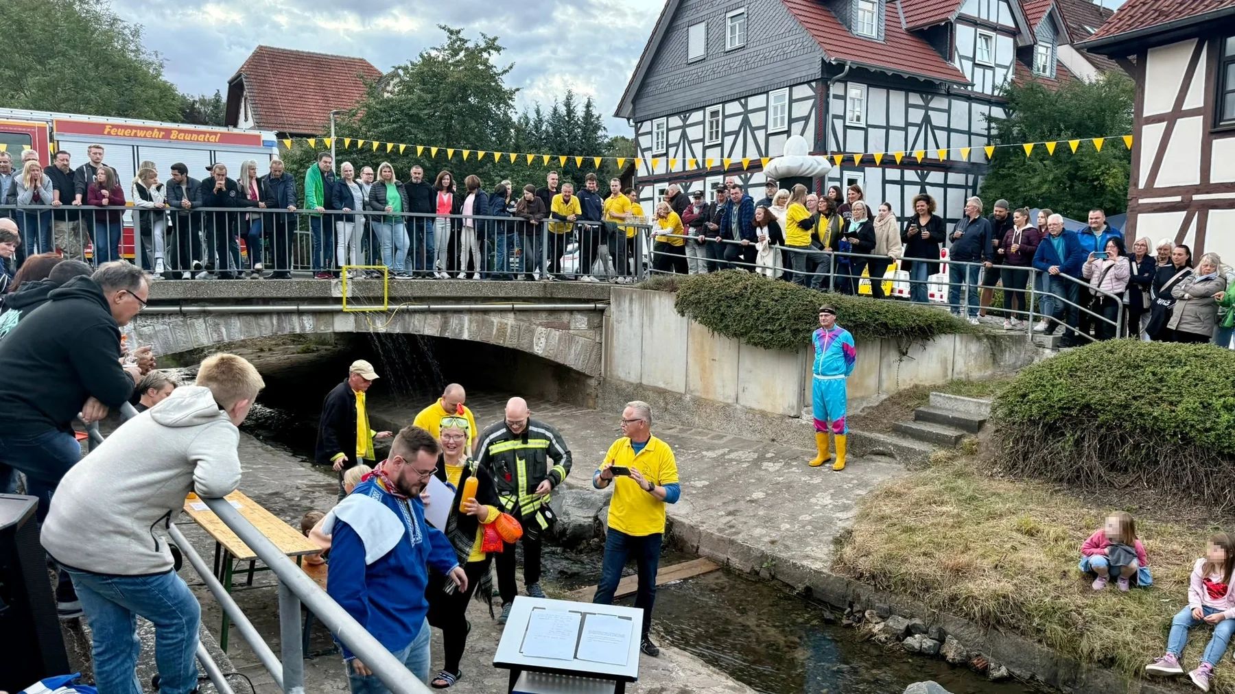 Kuckuckstaufe an der Bauna mit Publikum auf der Brücke